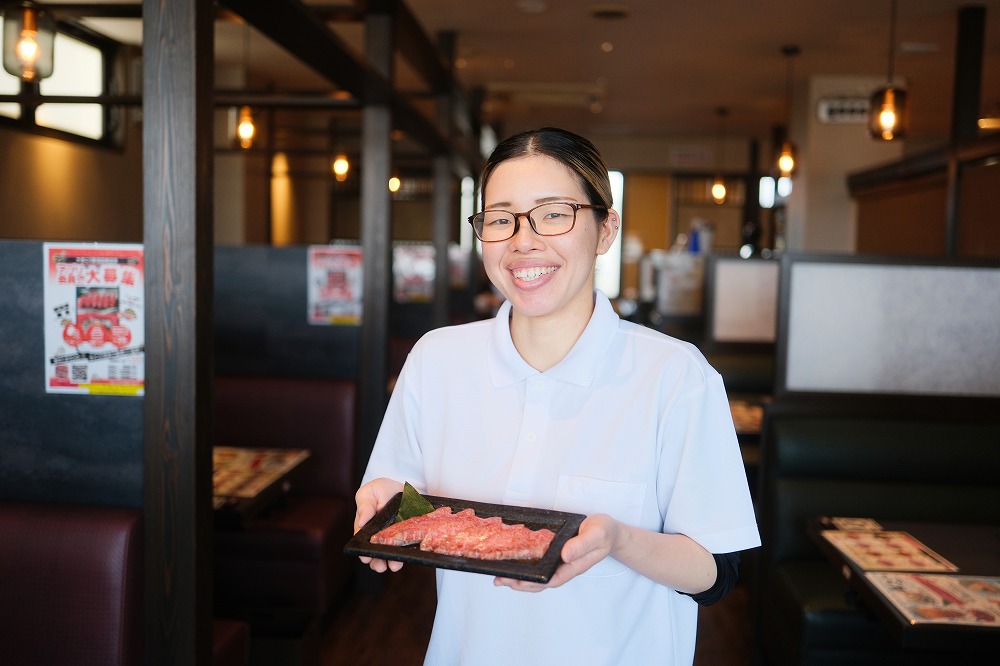 お肉を持った女性スタッフ