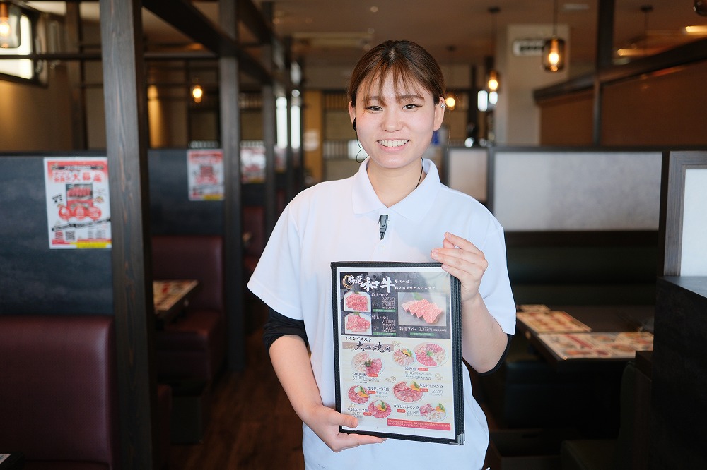 メニュー表を持った女性スタッフ