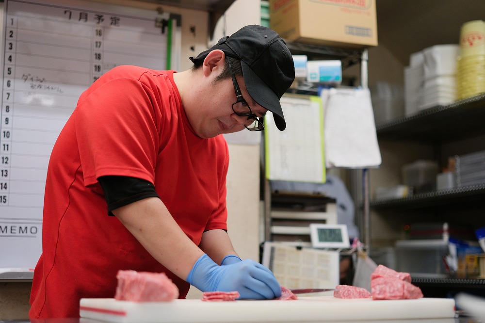 お肉を切っている男性スタッフ