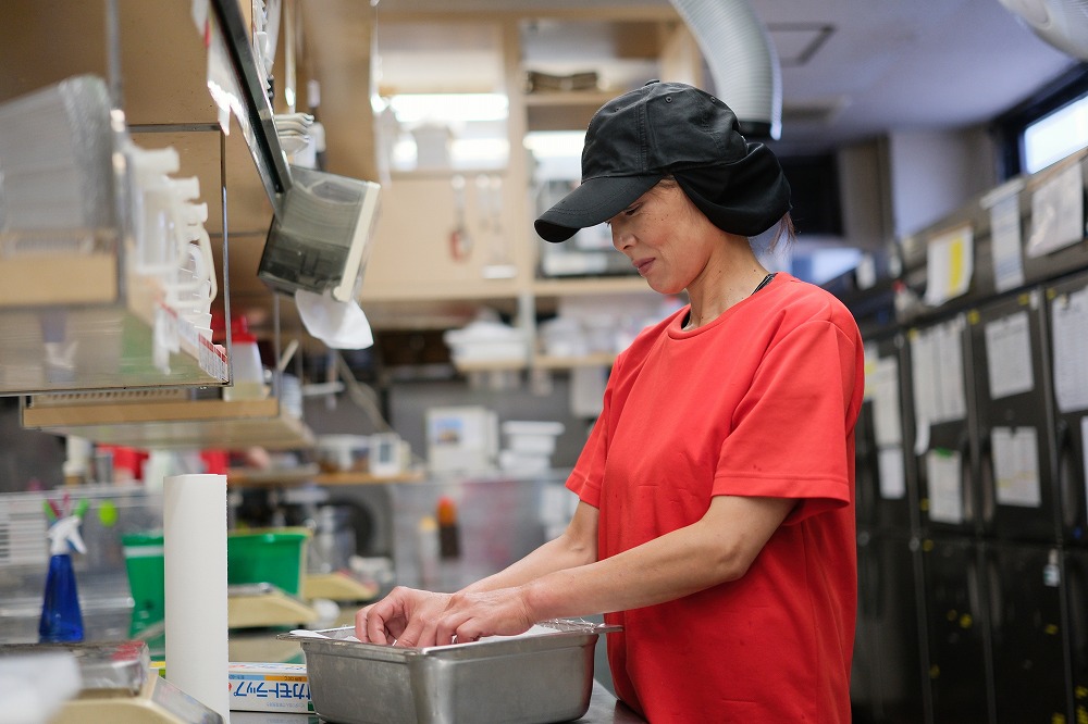 厨房で仕込みをしている女性スタッフ