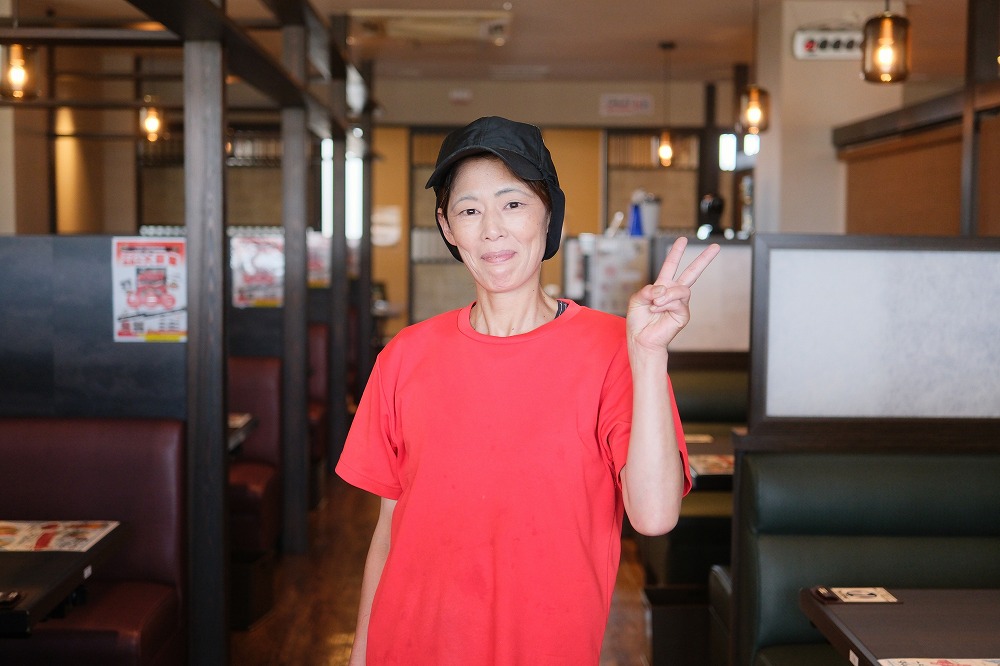 笑顔でピースしている女性スタッフ